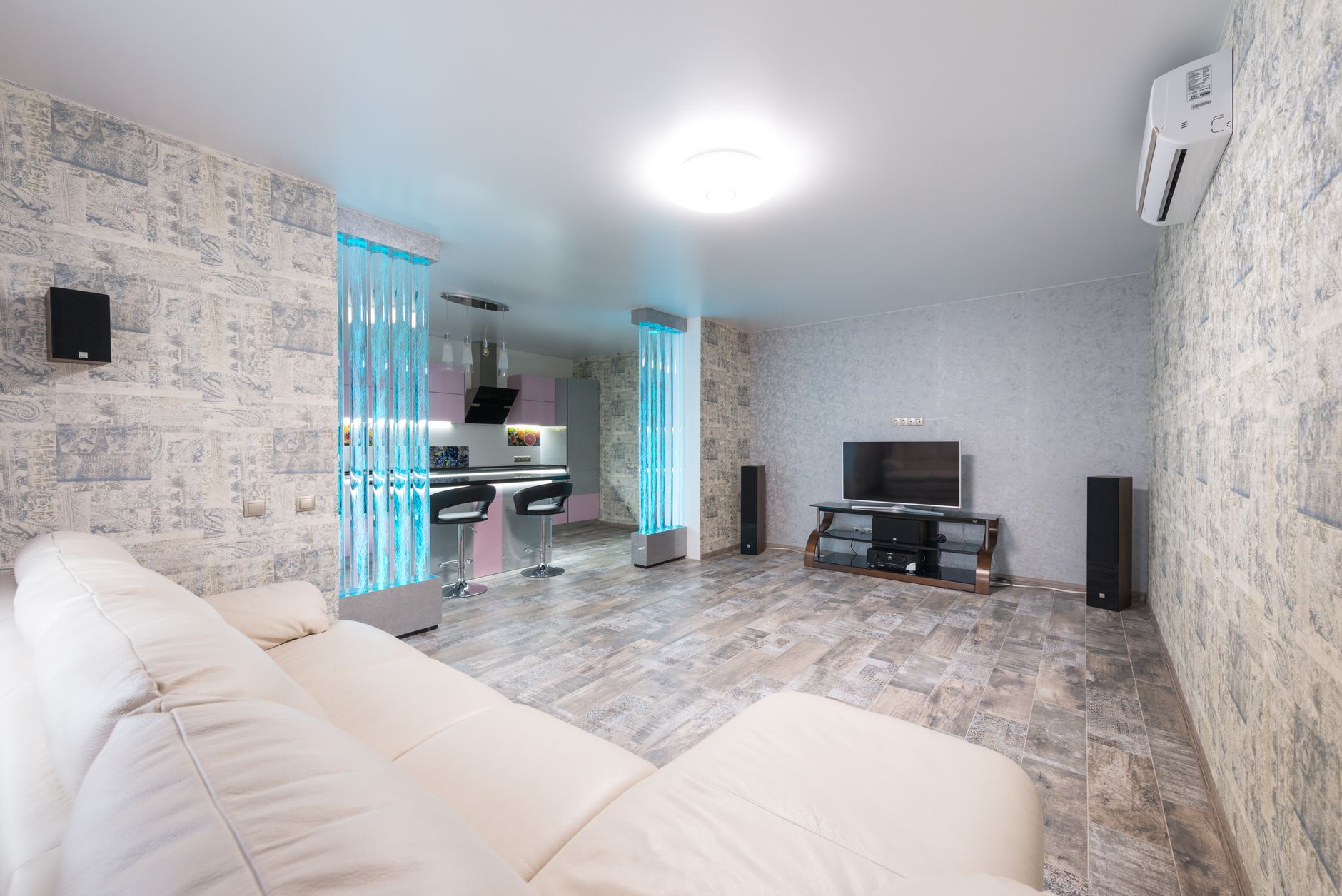 white air purifier standing on floor in a bright modern living room with sofa and plants