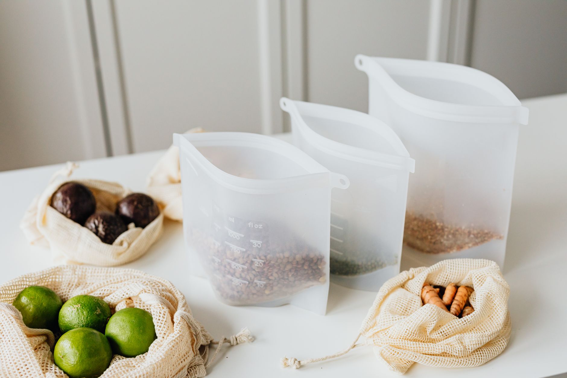 Colorful reusable silicone food storage bags on a wooden kitchen table