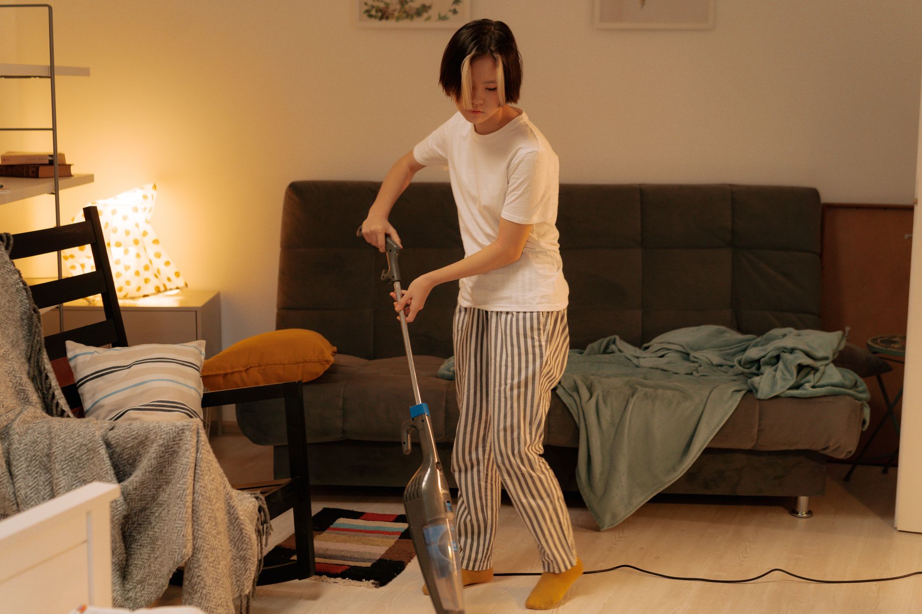 person vacuuming a living room floor with a HEPA vacuum cleaner