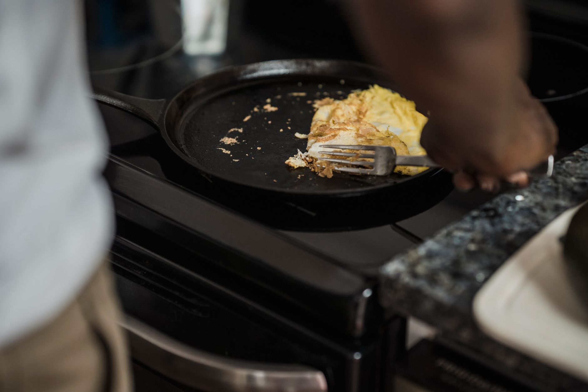 a bare cast iron skillet heating on a gas stove