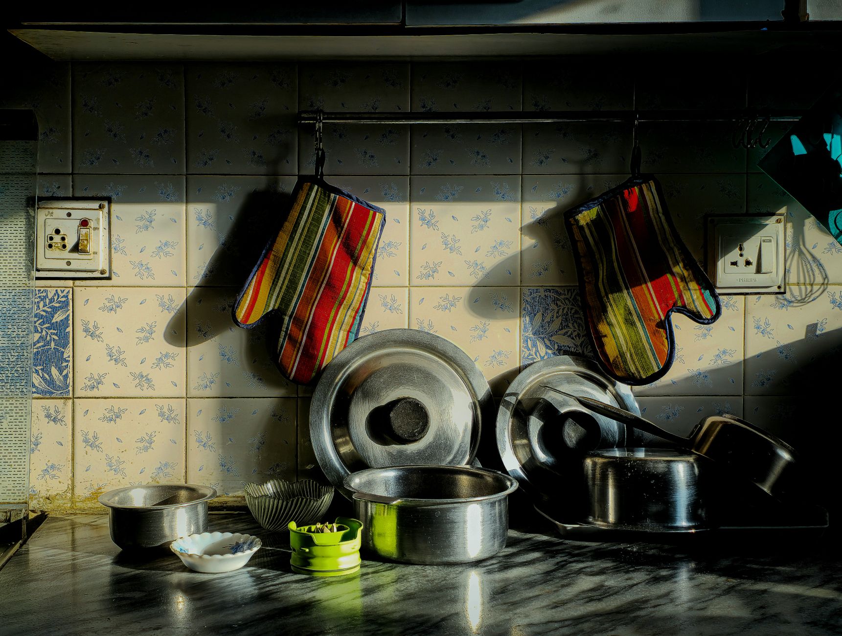 a set of stainless steel pots and pans hanging in a bright kitchen